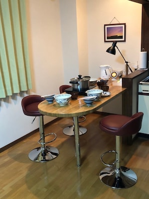Enjoy a convenient kitchen space with a dining table, kettle, and coffee maker, perfect for preparing hot beverages.