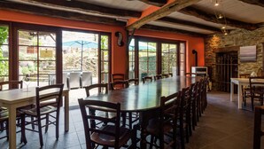 A long dining table with chairs, large windows, stone walls, and exposed wooden beams. - Tranquil Apartment in Sensenruth With Barbecue (Bouillon)