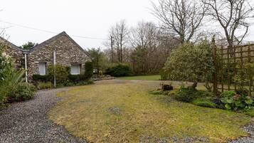 Surrounded by a beautifully maintained garden, this charming house features a pitched roof and a cozy chimney.