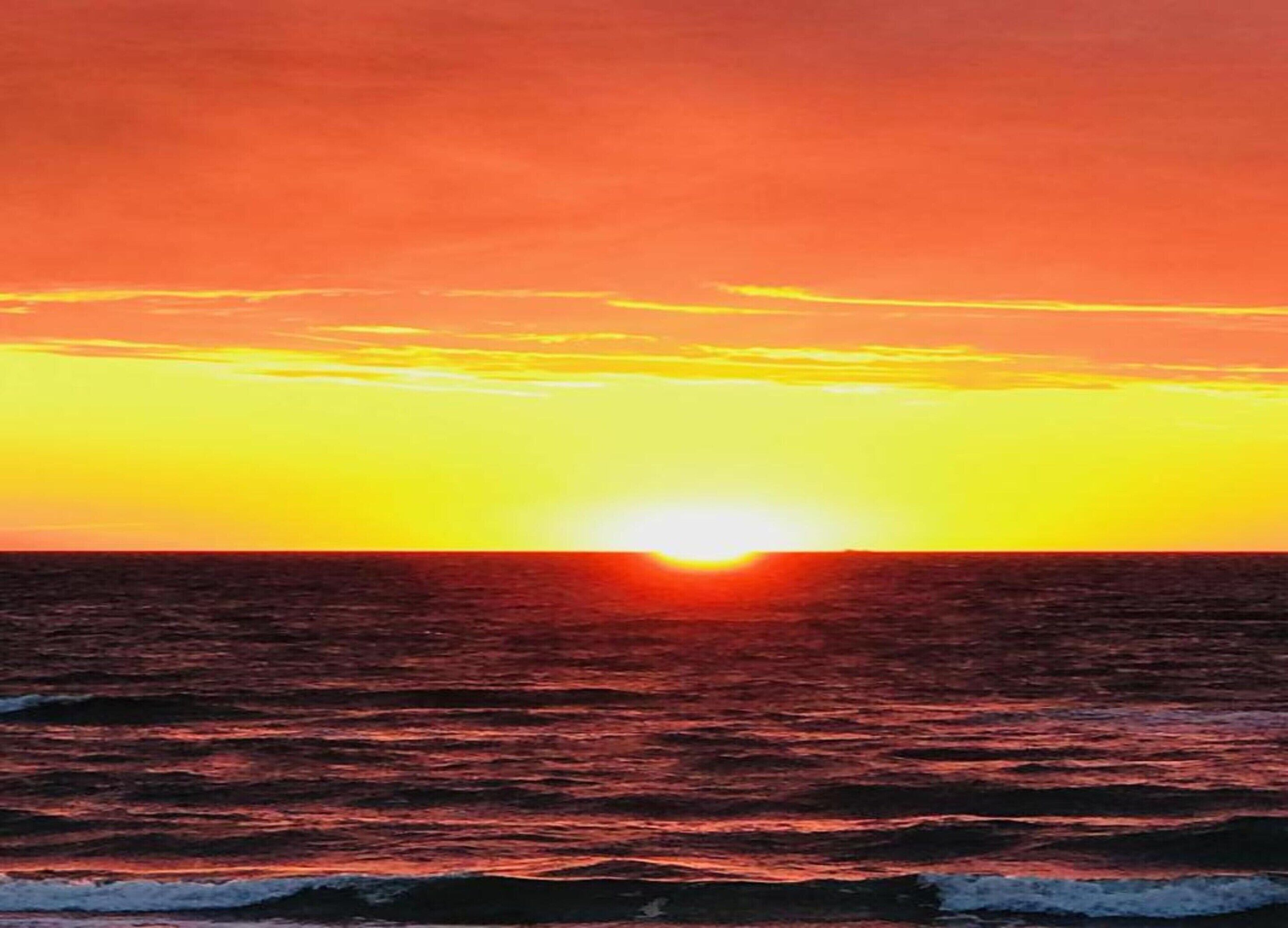 Ein Sonnenuntergang über dem Meer mit klarem Horizont.