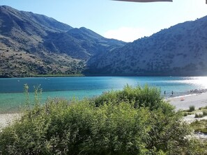 Paesaggio montuoso con un lago limpido e una spiaggia.