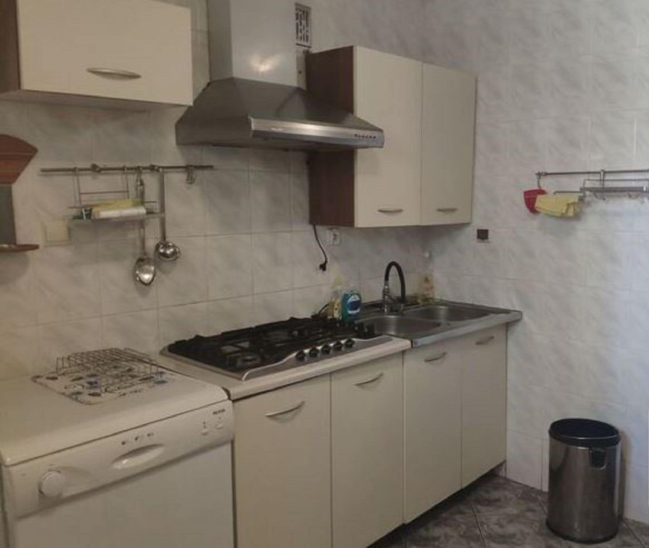 Keittiössä on valkoiset kaapit, ruostumattomasta teräksestä valmistettu liesituuletin, sisäänrakennettu uuni, pesuallas ja jääkaappi.