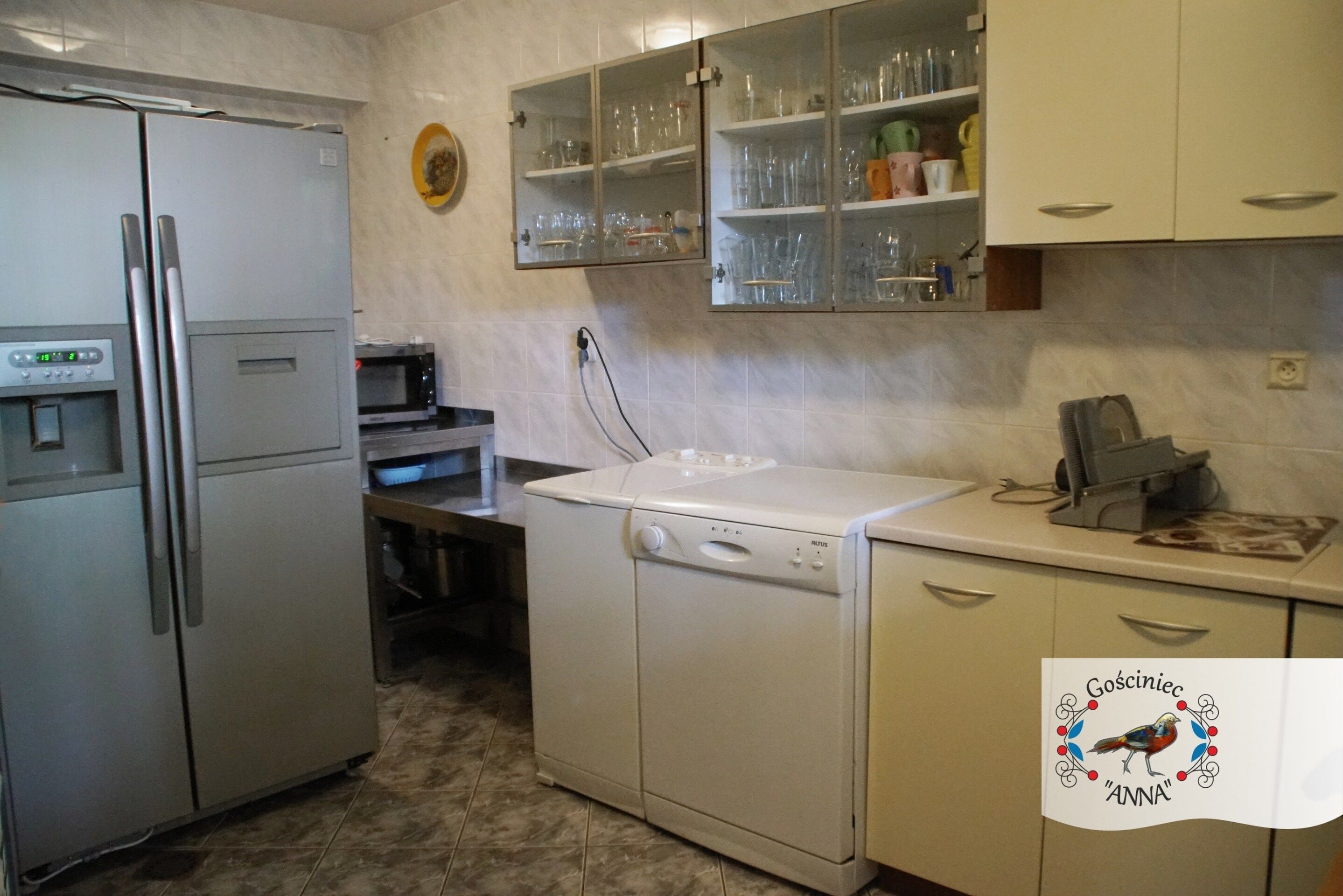 Cocina compacta con refrigerador, microondas, lavavajillas y armarios.