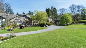 A residential area with stone houses, a gravel driveway, and a well-maintained lawn. - Bievre Forest-edge Retreat (Bievre)