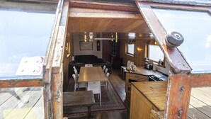 Een compact interieur van hout met een eethoek, keuken en zithoek.