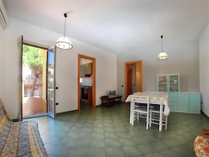 Cozy living space with a kitchenette, dining area, and sofa, offering a comfortable workspace and access to the balcony.