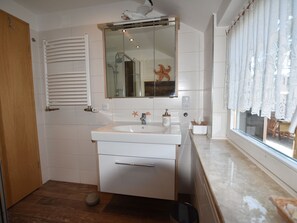 A bathroom with a white sink, mirror, and wooden floor. - Chic Stay Near Baltic Beach (Boltenhagen)