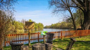 A riverside park with wooden benches, a wooden fence, and a signboard. - Lovely Apartment with Covered Terrace & Hot Tub (Crikvenica)