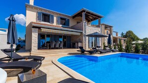 A modern villa with a swimming pool, outdoor seating, and a covered patio area. - Gorgeous Villa With Private Pool and Covered Terrace & Sea View (Kastelir-Labinci)
