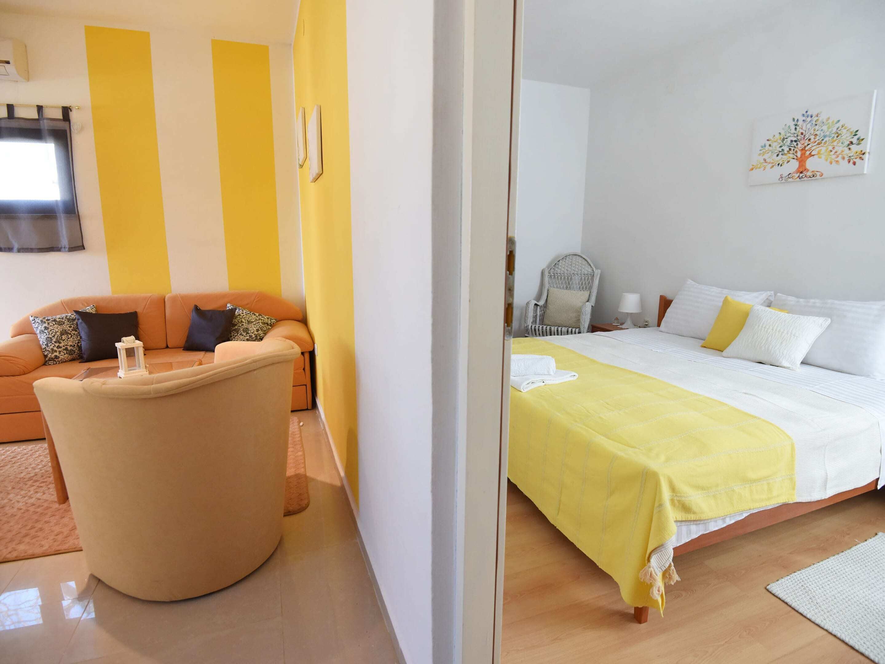 A hotel room with a bed, a sofa, and a chair.