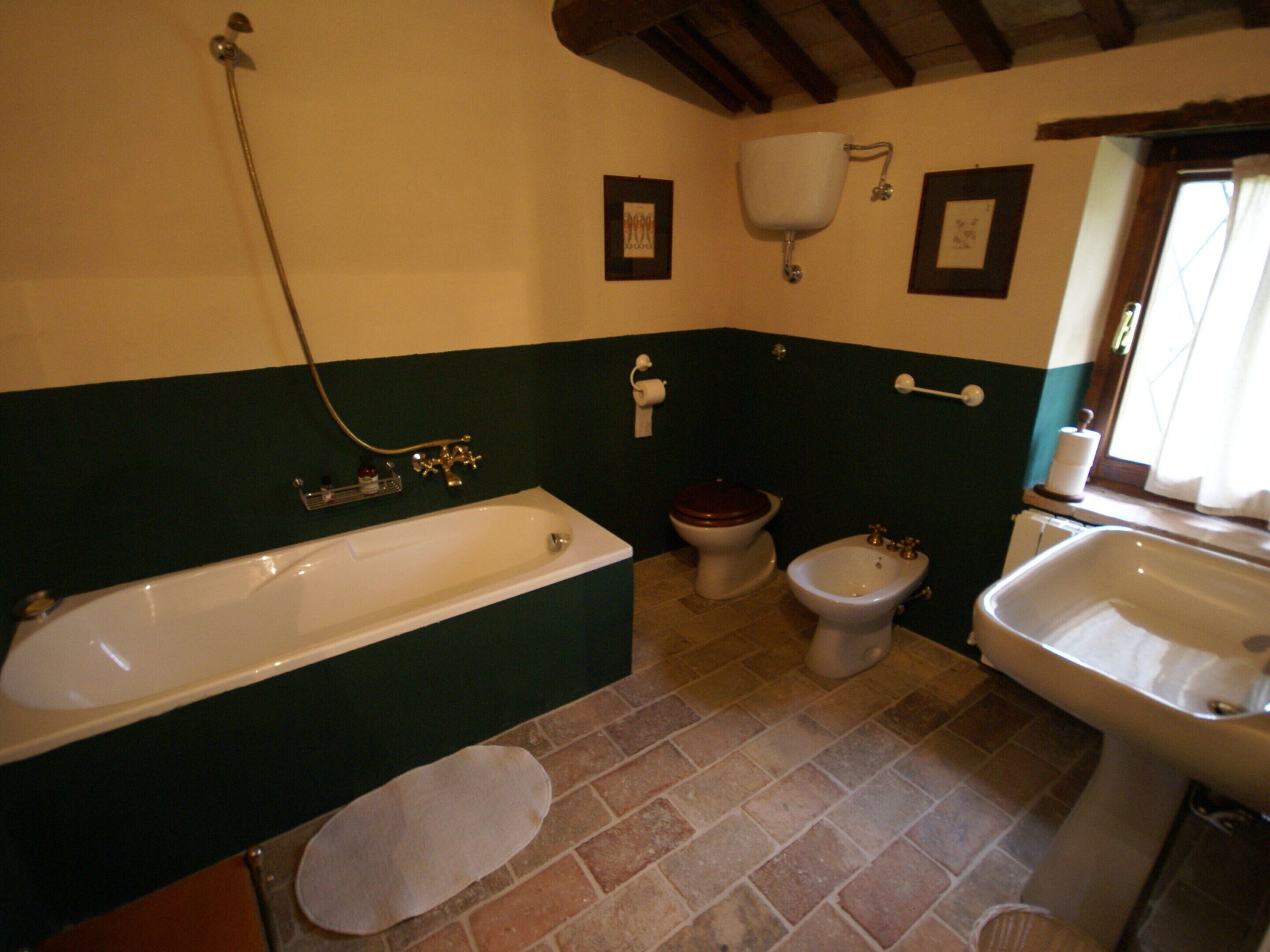 A bathroom with a bathtub, toilet, bidet, and sink.