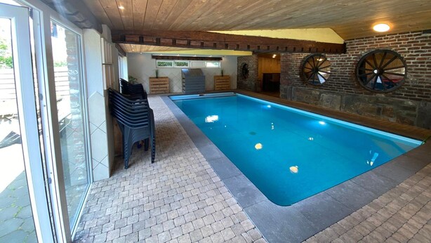 An indoor swimming pool with a wooden ceiling, brick walls, and a brick floor. - Spacious Waimes Villa (Waimes)