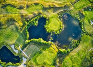 An aerial view of a golf course with multiple ponds and green areas. - Ferienwohnung in Steffenshagen mit Terrasse (Steffenshagen)