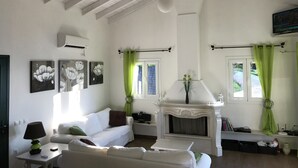A living room with a fireplace, white furniture, and green curtains. - Comfy Apartment in Vinkuran With the Beach Nearby (Corfu)
