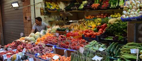 A market stall with various fruits and vegetables on display.
