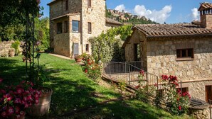 A stone building with a garden, a stone staircase, and a view of a village in the background. - Rustic Villa with Private Pool near Montepulciano (Montepulciano)