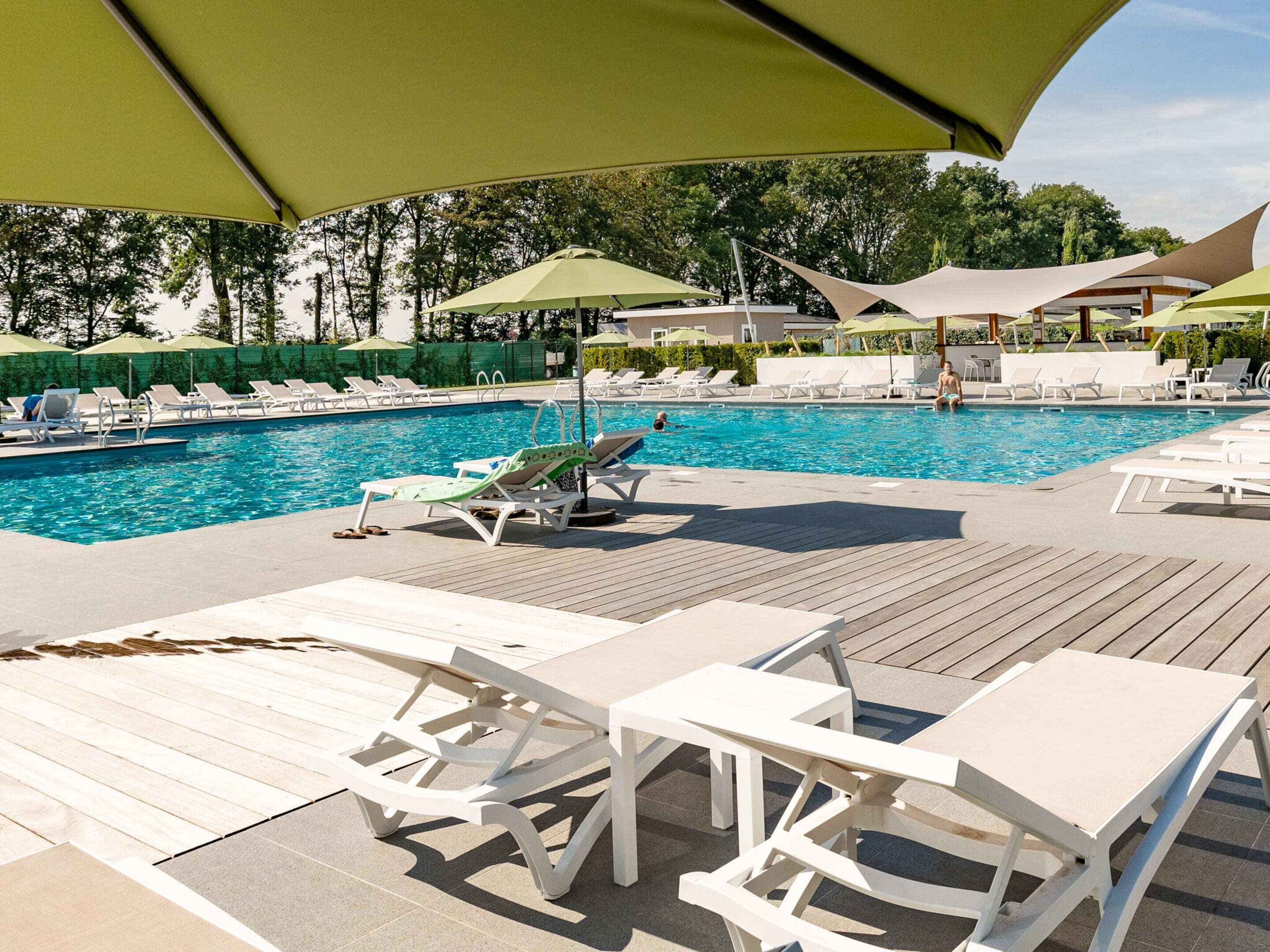A poolside area with lounge chairs and umbrellas.
