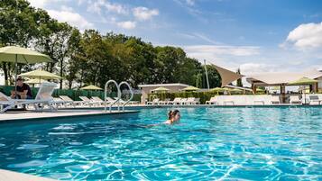 Ein Schwimmbad mit Liegestühlen und Sonnenschirmen.