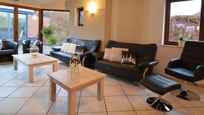 Et moderne loungeområde med sofa, lænestole og sofabord.