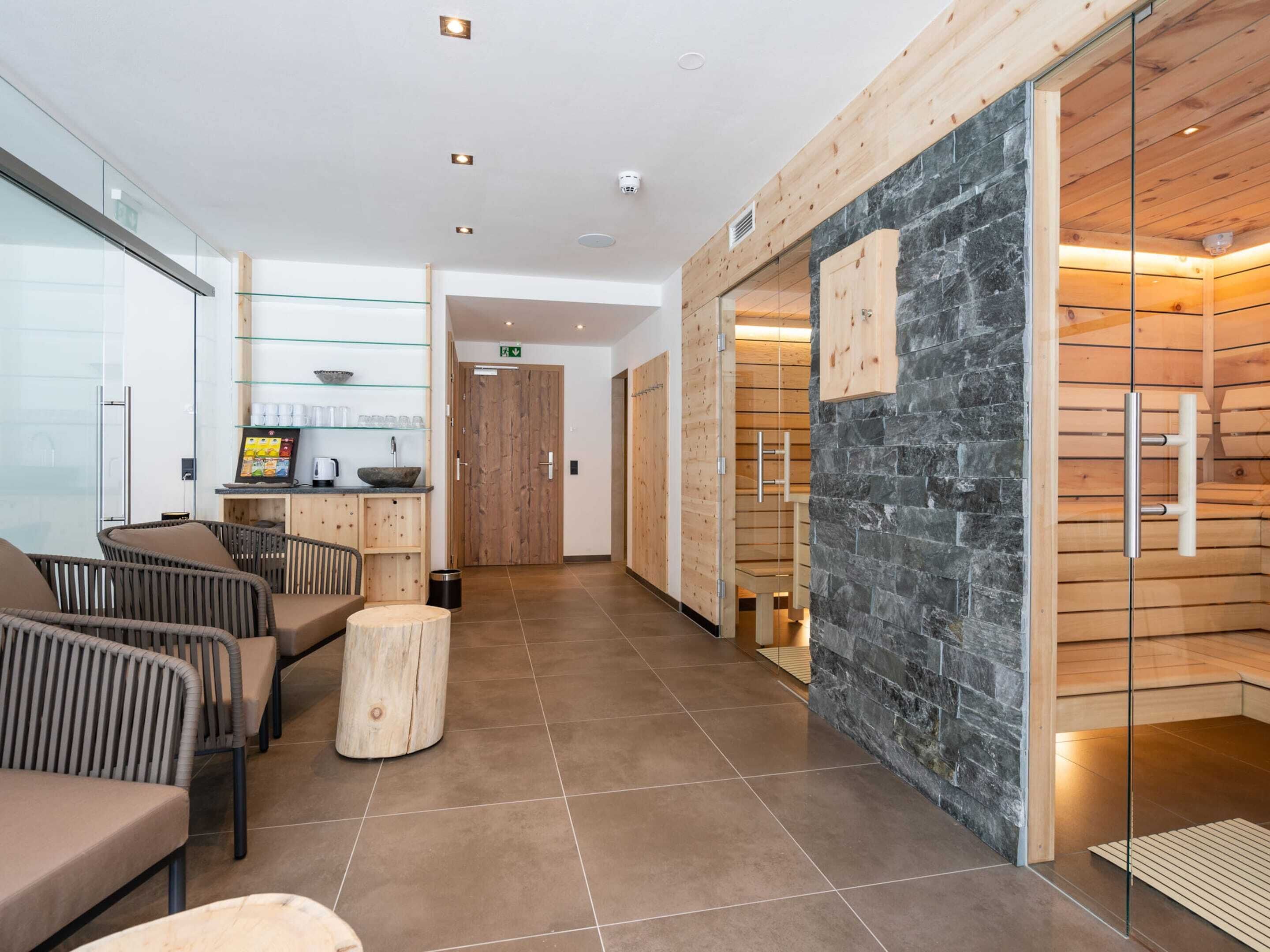 A modern reception area with a wooden reception desk, seating area, and a stone wall.