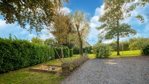 A gravel driveway leading to a house with a swing set and a small garden area. - Holiday Home in Montleban With Garden (Gouvy)