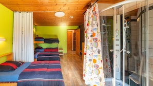 A room with bunk beds, a shower area with glass doors, and a wooden ceiling. - Holiday Home in Montleban With Garden (Gouvy)