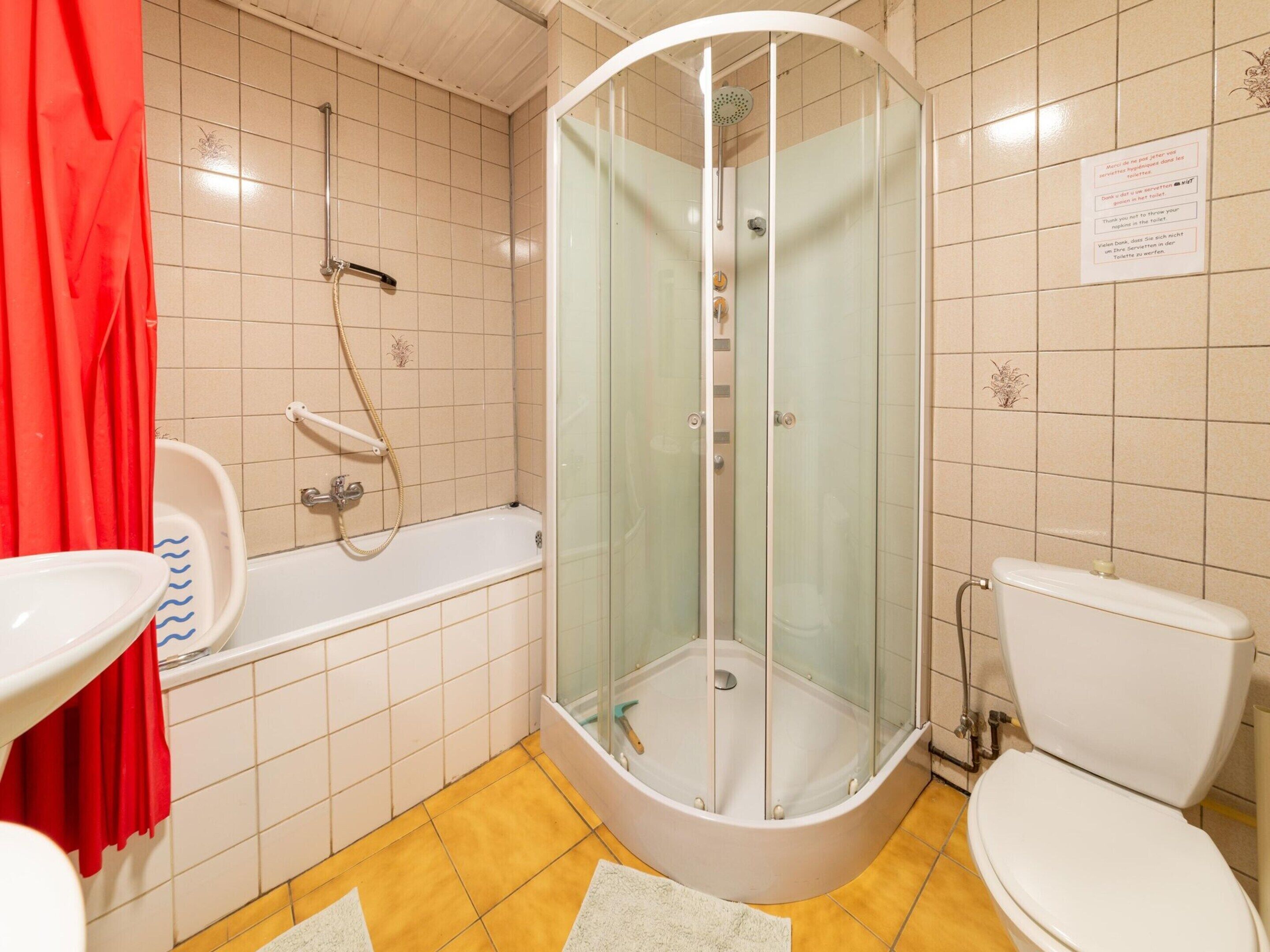 Une salle de bain avec une douche à parois de verre, une baignoire, des toilettes et un lavabo.