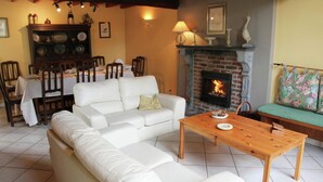 Una sala de estar con un sofá blanco, una mesa de centro de madera y una chimenea.