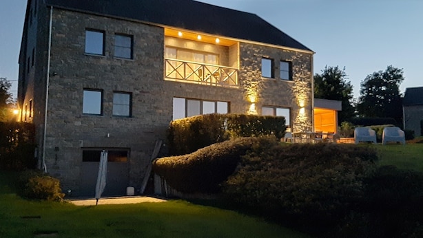 A stone house with a two-story layout, a balcony, and a well-maintained lawn. - Scenic Cottage in Rahier (Stoumont)