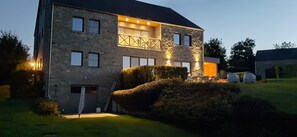 A stone house with a two-story layout, a balcony, and a well-maintained lawn. - Scenic Cottage in Rahier (Stoumont)