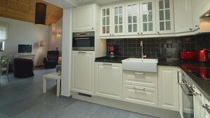 A modern kitchen with white cabinetry, a black countertop, and a skylight. - Scenic Cottage in Rahier (Stoumont)
