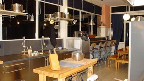 A modern kitchen with stainless steel appliances, a wooden table, and a dining area with chairs. - Beautiful Country House in the Ardennes With Lots of Privacy (La Roche-en-Ardenne)
