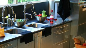 A modern kitchen with stainless steel appliances, a double sink, and a window providing natural light. - Beautiful Country House in the Ardennes With Lots of Privacy (La Roche-en-Ardenne)