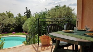 An outdoor patio with a pool, a table with chairs, and a view of the surrounding greenery. - New Villa, Round Swimmingpool, Beautiful View (Saint-Laurent-de-Carnols)