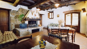 Un intérieur rustique avec une cheminée en pierre, des meubles en bois et une table à manger.