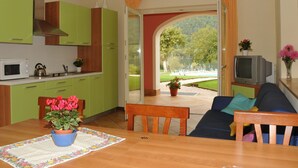 A compact living space with a kitchen, dining area, and a view of a lake. - Apartment in Idro With Pool and Garden (Idro)