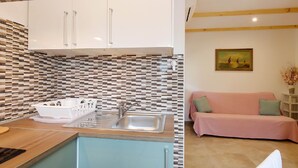 A compact kitchen with a sink, cabinets, and a patterned backsplash. - Apartment in Silo With Sea View Balcony (Dobrinj)