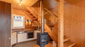 A wooden interior with a kitchen, a stove, and a staircase. - Luxury Retreat With Relaxing Bubble Bath (Hohentauern)