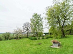 Escape to a serene garden oasis with lush greenery and mature trees providing shade.