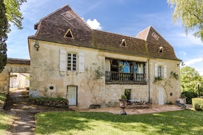 A stone house with a balcony, a garden, and a paved patio. - Mansion in Sourzac With Private Pool (Sourzac)