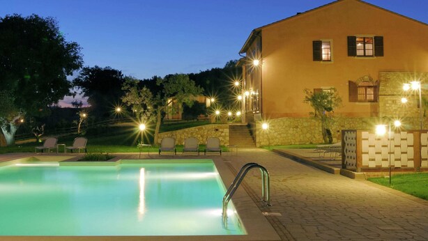 A pool area with a clear pool, a metal ladder, and lounge chairs. - Luxury, Modern Apartment With Pool and Stunning Views (Narni)