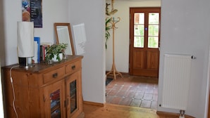 A room with a wooden cabinet, a radiator, and a door leading to another room. - Ferienhaus in Herrischried (Herrischried)