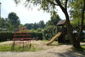 A playground with a slide, a climbing structure, and a small shelter. - Family Home w/ Trampoline (Haaren)