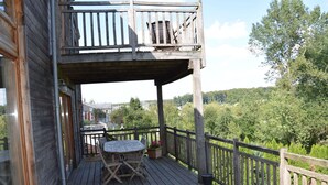 A wooden deck with a table and chairs, overlooking a forested area. - Fort-like Holiday Home in Sart-bertrix, Near Luxembourg (Bertrix)