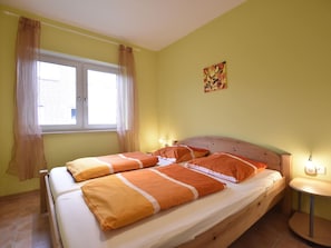 Cozy bedroom with a comfortable bed, bedside table, and artwork.