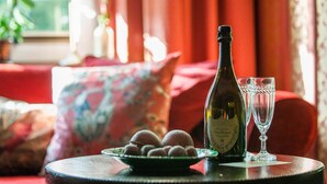 A table with a bottle of champagne, two glasses, and a plate of round pastries. - Timeless Charm in Gernrode (Quedlinburg)