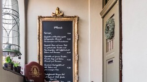 A blackboard menu with a gold frame, a vintage chair, and a birdcage. - Timeless Charm in Gernrode (Quedlinburg)