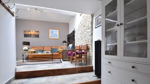 A living room with a sofa, chairs, a cabinet, and a staircase leading to another room. - Quiet Normandy Retreat (La Haye)