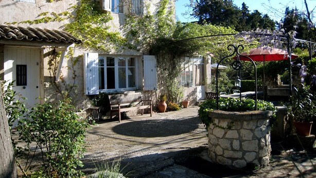 A stone building with a balcony, a bench, and potted plants. - Holiday Home in Provence With Private Pool (Cavaillon)