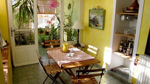 A dining area with a table, chairs, a bench, a pitcher, and a lamp. - Holiday Home in Provence With Private Pool (Cavaillon)